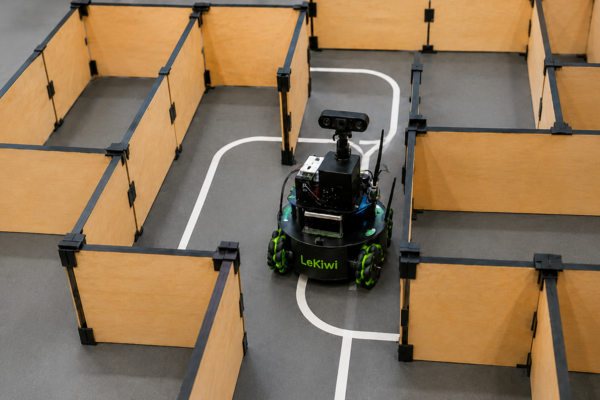 Lekiwi Platform im Labirint in einem kleinen Labyrinth fährt ein kleiner Roboter mit Kameraaugen herum